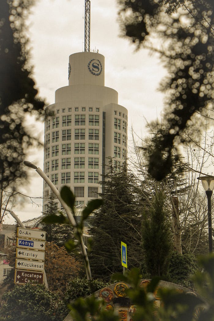 Mastering the First Impression: Your intriguing post title goes here View of the Sheraton Tower in Ankara with surrounding greenery and directional signs.