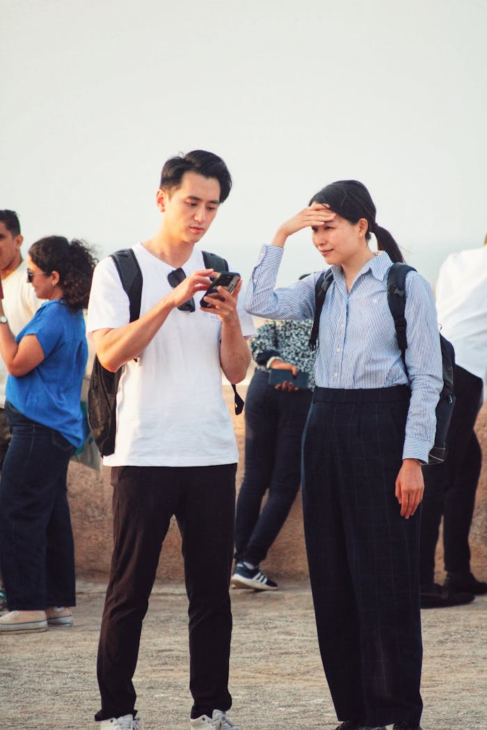 Crafting Captivating Headlines: Your awesome post title goes here Two adults using smartphone for navigation while sightseeing outdoors. Casual travel scene.